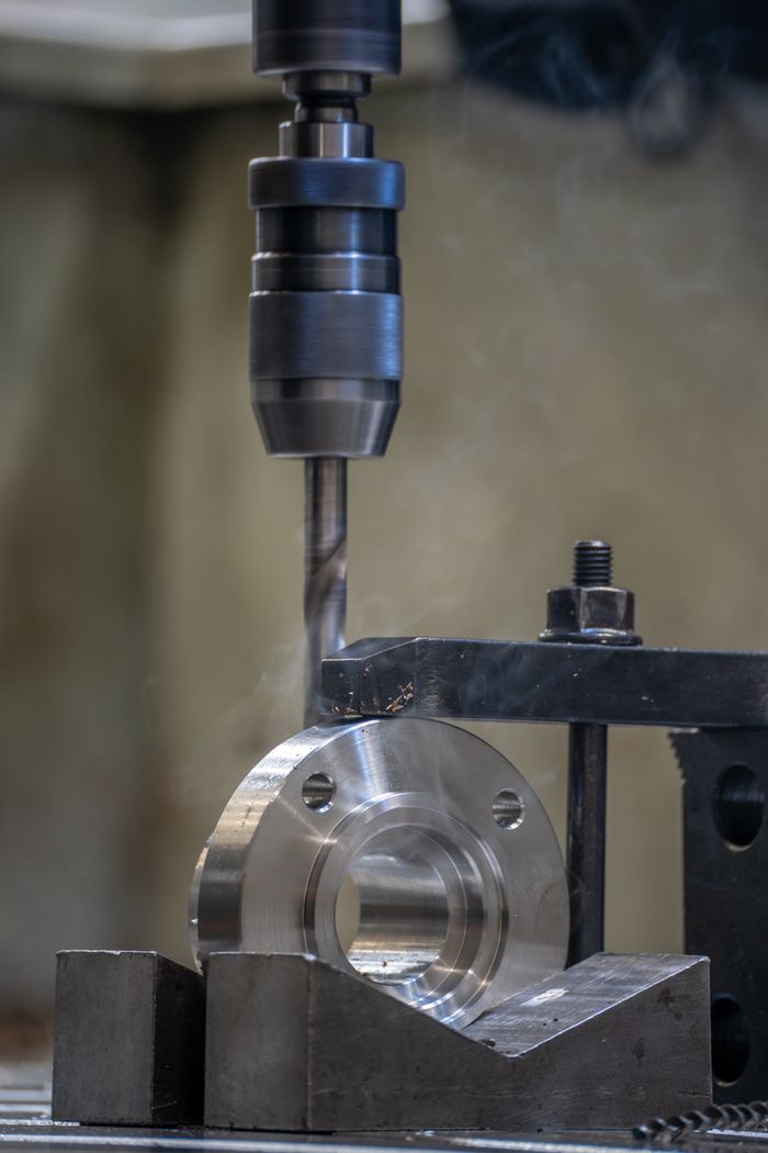Close-up view of a metal drilling process in an industrial workshop setting.